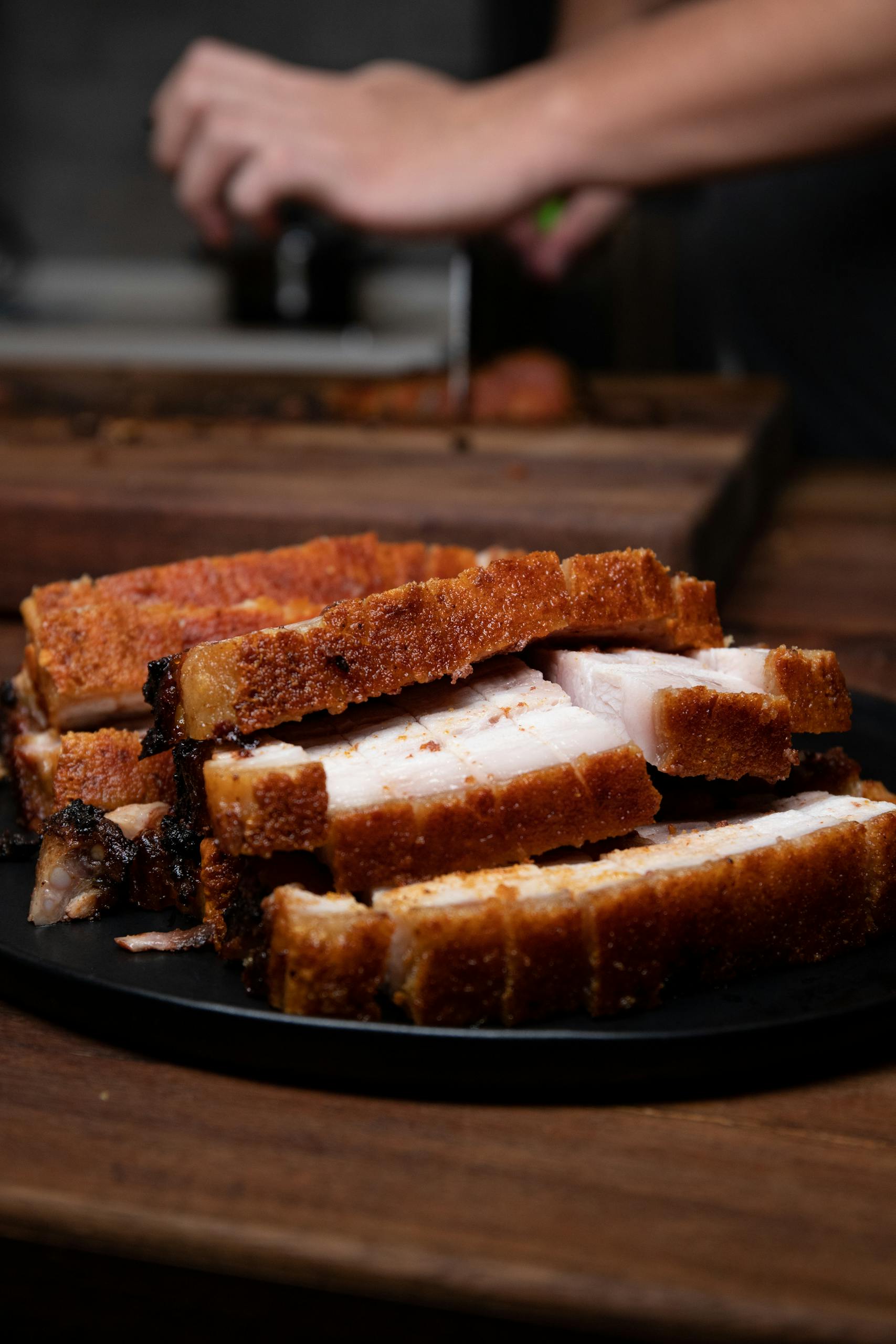 Delicious crispy roasted pork belly slices on a plate, a perfect tasty meal.